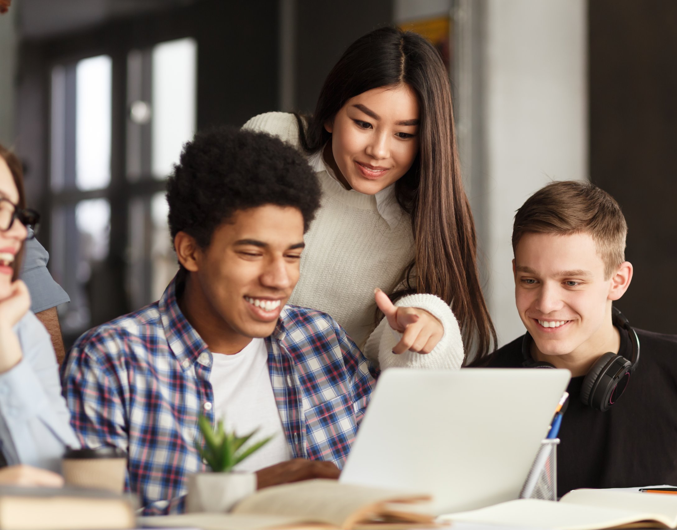 Group of students looking at a laptop together